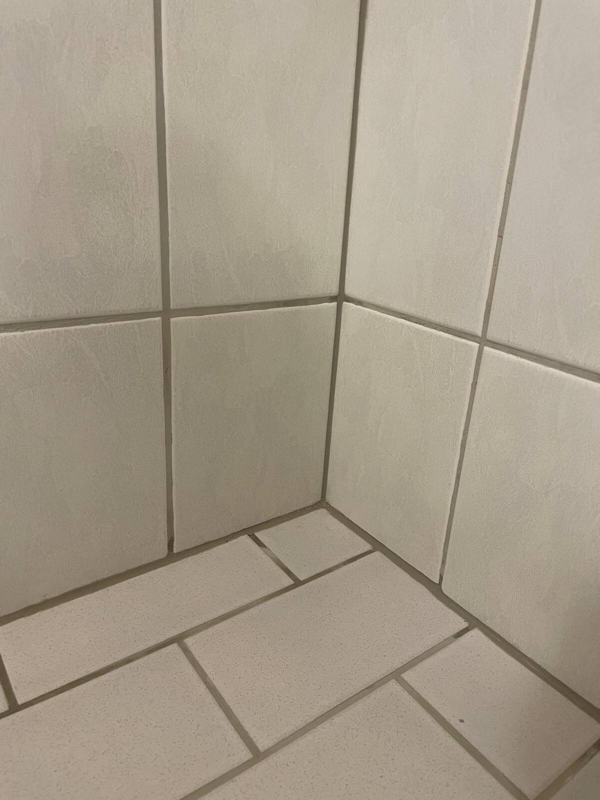 Vaaleat laatat kulmauksessa, joissa saumojen väri on hieman tumma.